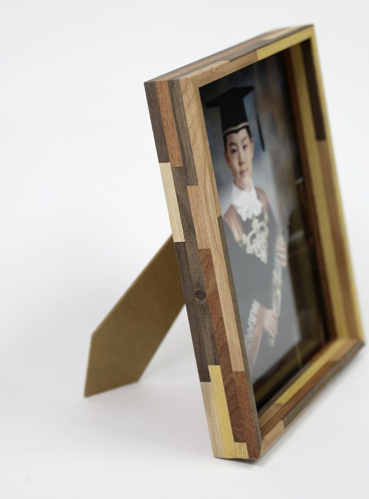 같은 원목 액자를 옆에서 본 모습 — 짜맞춘 나뭇결과 받침대